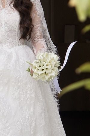Mariée tenant un bouquet d'arums blancs