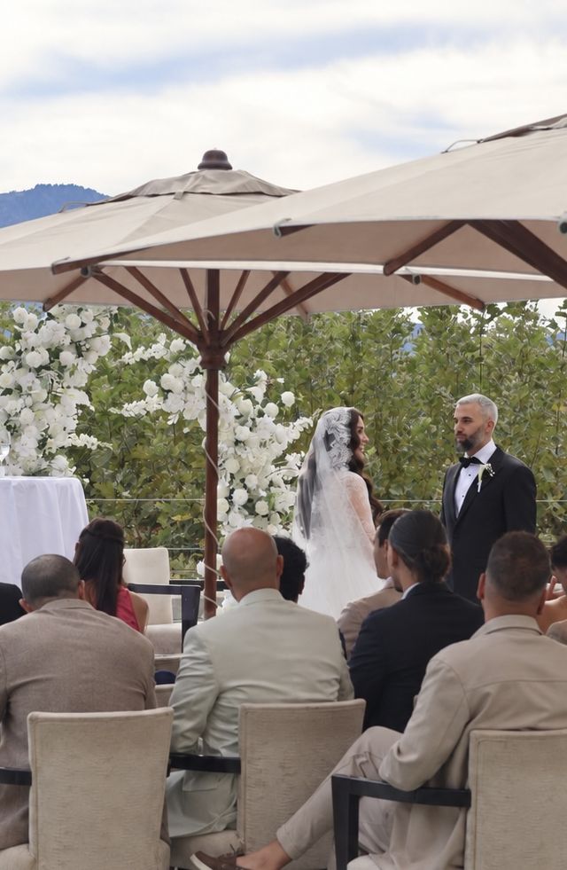 Cérémonie de mariage en terrasse avec arche fleurie et invités